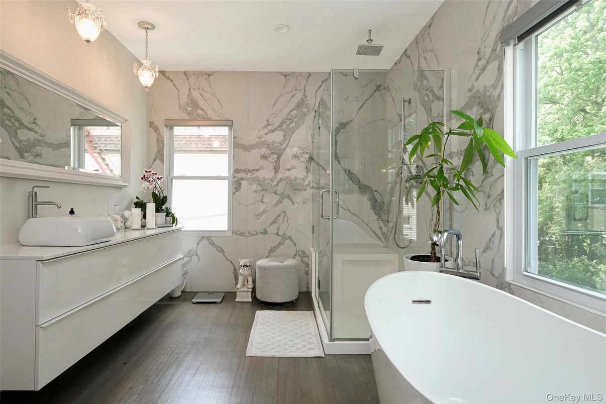 Bathroom, Chandelier, Dual Sink Vanities, Free Standing Baths, Glass Shower, Interior, Marble Walls, Pendant Lights, Recessed Lighting, Wood Texture Flooring