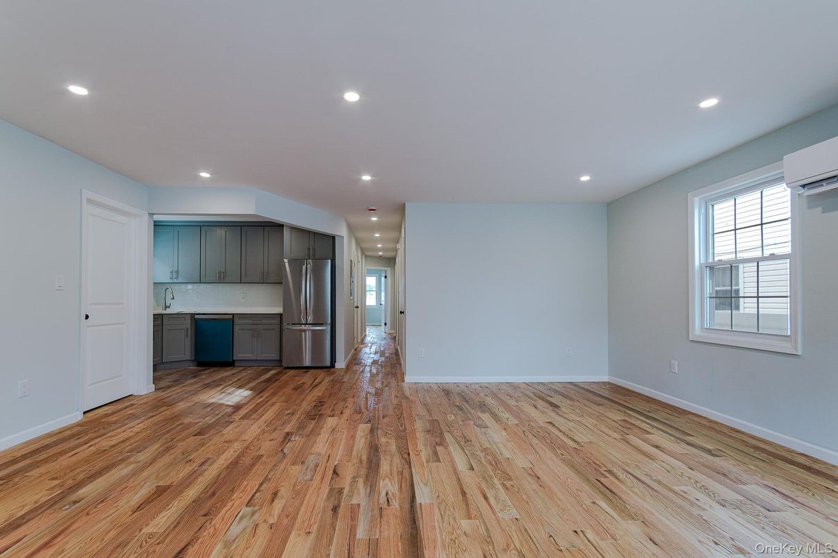 Empty room, Interior, Kitchen, Recessed Lighting, Stainless Steel Appliances, Wood Texture Flooring