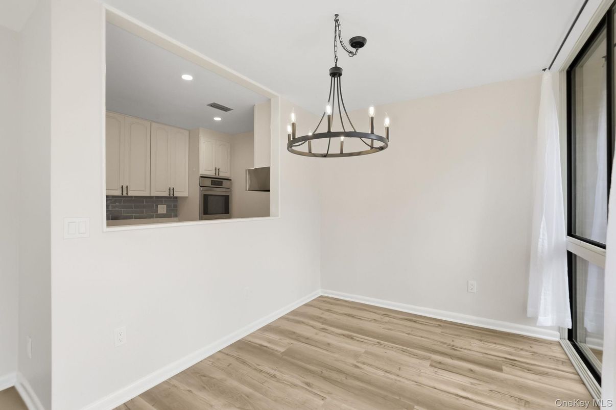 Chandelier, Empty room, Interior, Kitchen, Pendant Lights, Recessed Lighting, Stainless Steel Appliances, Wood Texture Flooring