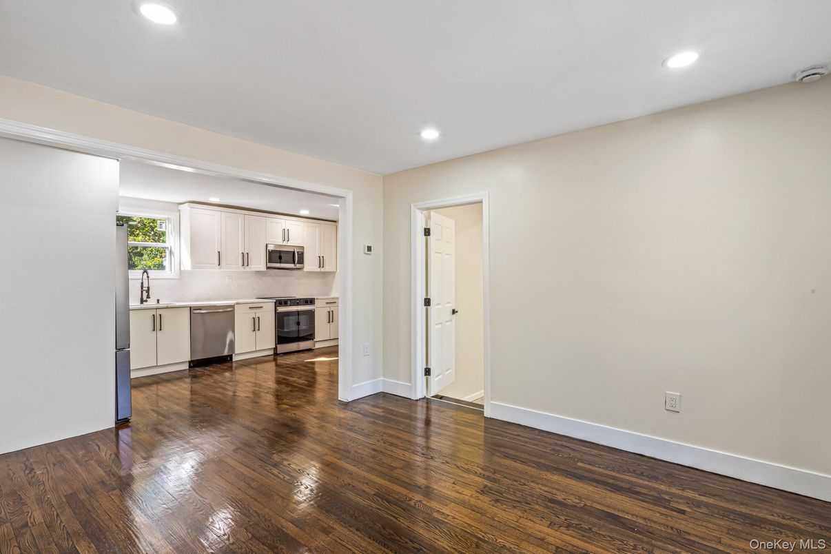 Empty room, Interior, Kitchen, Recessed Lighting, Stainless Steel Appliances, Wood Texture Flooring