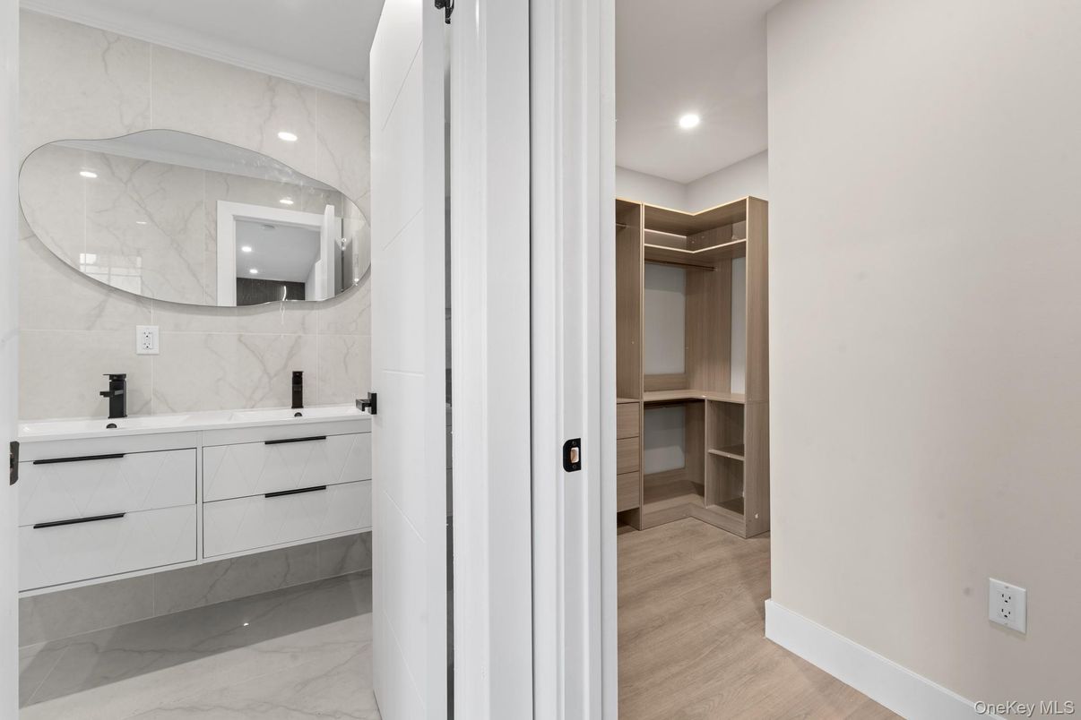 Bathroom, Dual Sink Vanities, Interior, Marble, Marble Walls, Recessed Lighting, Walk-in Closets, Wood Texture Flooring