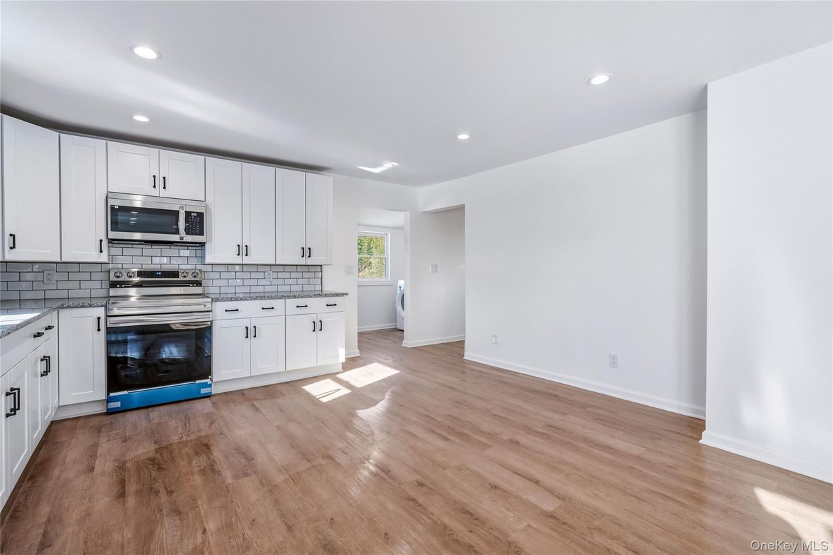 Empty room, Interior, Kitchen, Recessed Lighting, Stainless Steel Appliances, Wood Texture Flooring