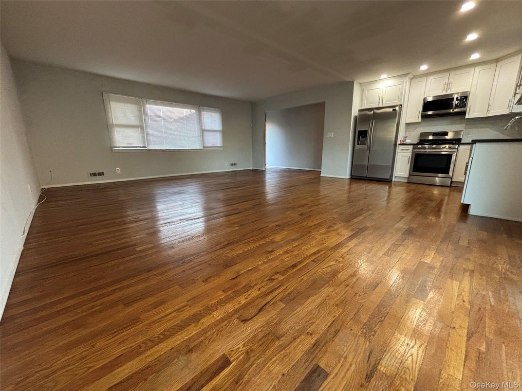 Empty room, Interior, Kitchen, Recessed Lighting, Stainless Steel Appliances, Wood Texture Flooring