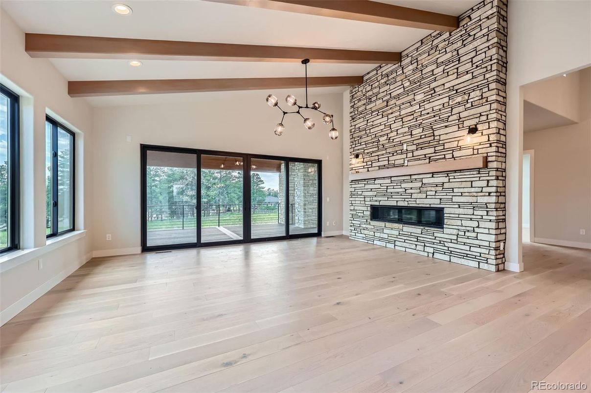 Empty room, Fireplace, Interior, Pendant Lights, Recessed Lighting, Stone Walls, Wooden Beams, Wood Texture Flooring