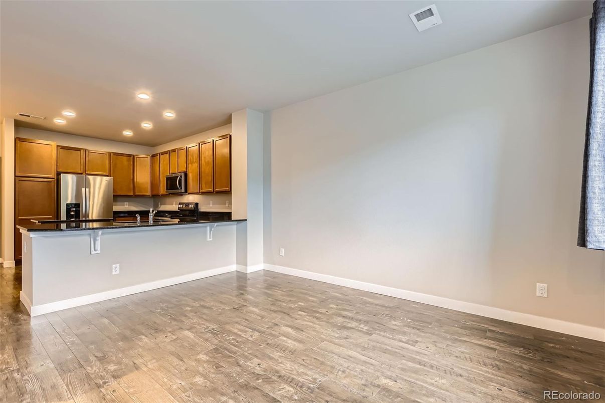 Empty room, Interior, Kitchen, Recessed Lighting, Stainless Steel Appliances, Wood Texture Flooring