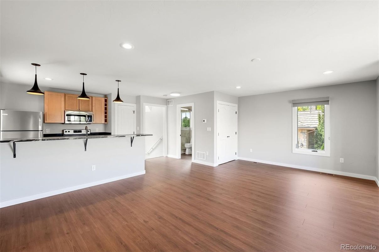 Empty room, Interior, Kitchen, Pendant Lights, Recessed Lighting, Stainless Steel Appliances, Wood Texture Flooring