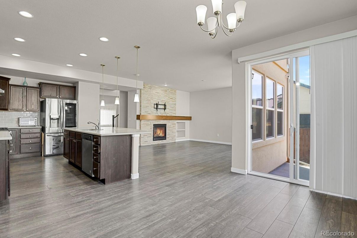 Fireplace, Interior, Kitchen, Pendant Lights, Recessed Lighting, Stainless Steel Appliances, Stone Walls, Wood Texture Flooring
