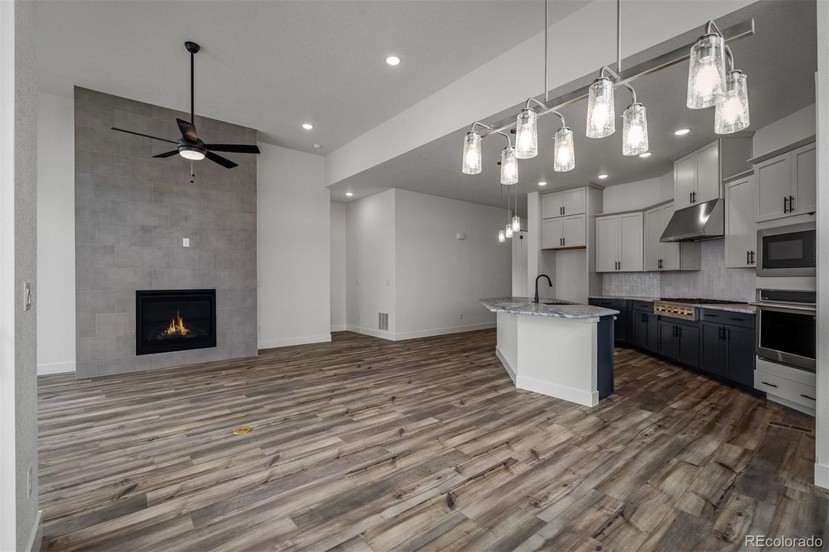 Empty room, Fireplace, Interior, Kitchen, Pendant Lights, Recessed Lighting, Stone Walls, Wood Texture Flooring