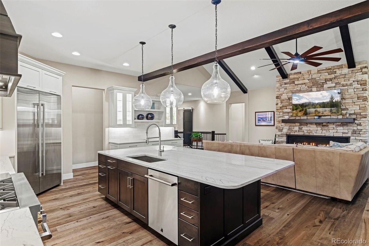 Fireplace, Interior, Kitchen, Living room, Pendant Lights, Recessed Lighting, Stainless Steel Appliances, Stone Walls, Wood Texture Flooring