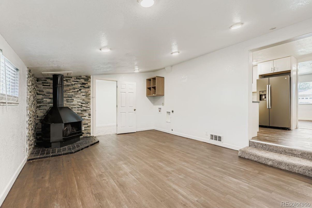 Empty room, Fireplace, Interior, Kitchen, Recessed Lighting, Stone Walls, Wood Texture Flooring