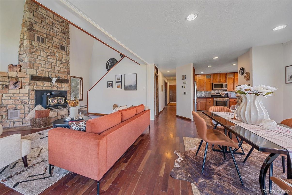 Dining room, Fireplace, Interior, Kitchen, Living room, Recessed Lighting, Stainless Steel Appliances, Stone Walls, Wood Texture Flooring