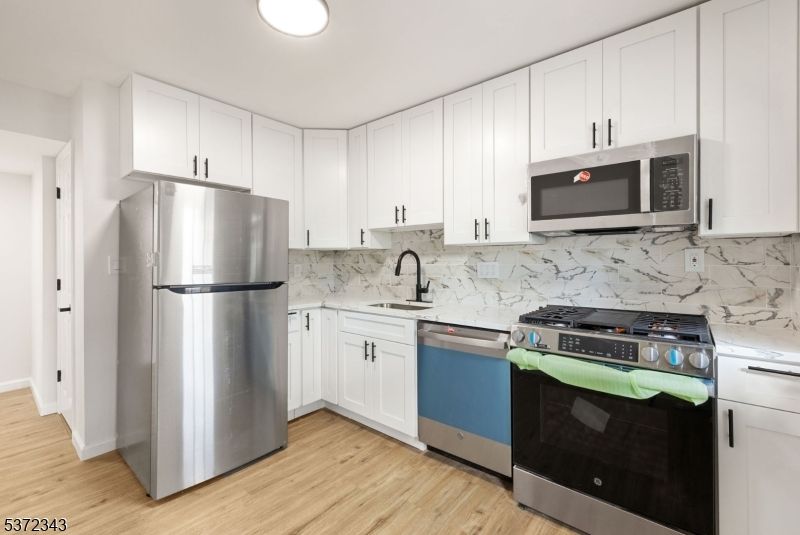 Interior, Kitchen, Marble Walls, Recessed Lighting, Stainless Steel Appliances, Wood Texture Flooring