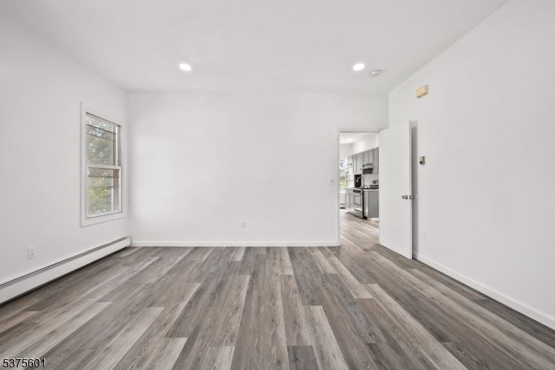 Empty room, Interior, Kitchen, Recessed Lighting, Stainless Steel Appliances, Wood Texture Flooring