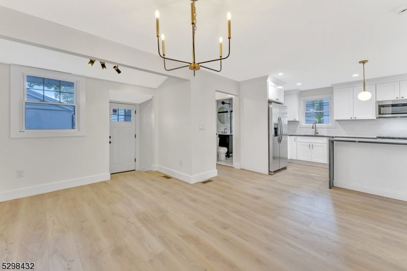 Chandelier, Empty room, Interior, Kitchen, Pendant Lights, Recessed Lighting, Stainless Steel Appliances, Wood Texture Flooring