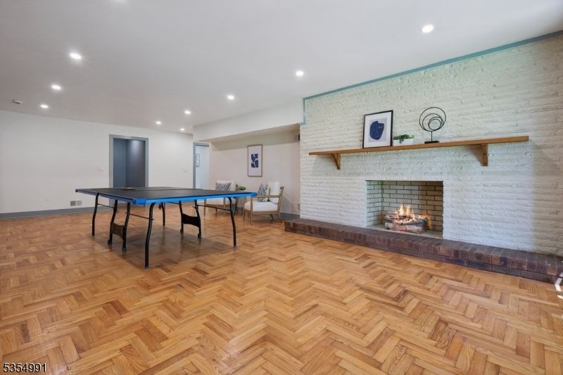 Fireplace, Game Room, Interior, Recessed Lighting, Stone Walls, Wood Texture Flooring