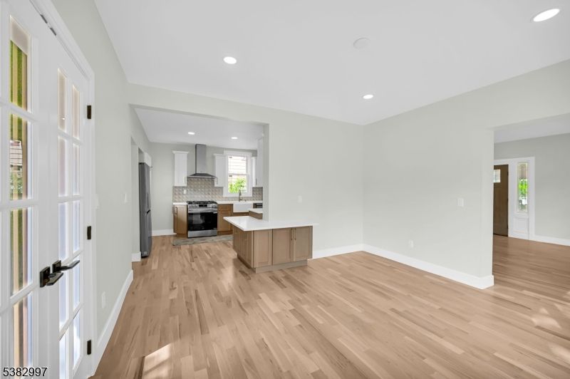 Empty room, Interior, Kitchen, Recessed Lighting, Stainless Steel Appliances, Wood Texture Flooring