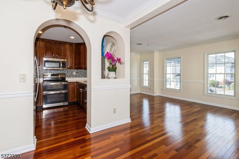 Empty room, Interior, Kitchen, Recessed Lighting, Stainless Steel Appliances, Wood Texture Flooring