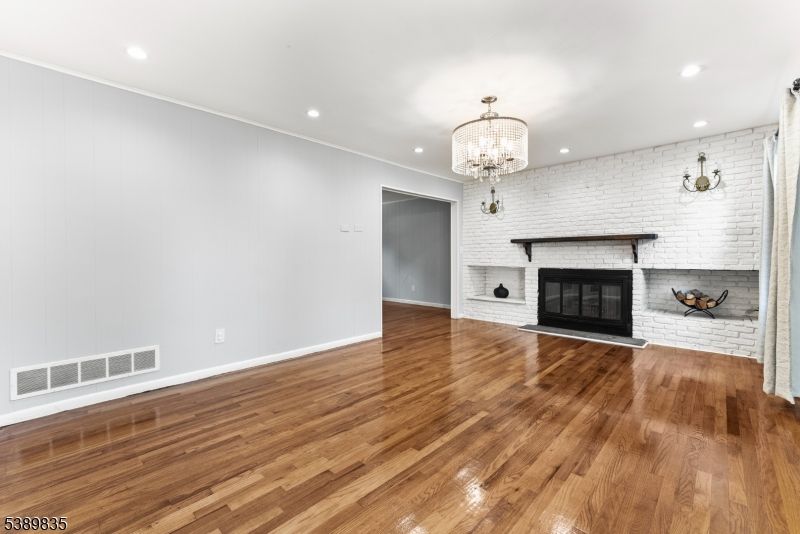 Chandelier, Empty room, Fireplace, Interior, Recessed Lighting, Stone Walls, Wood Texture Flooring