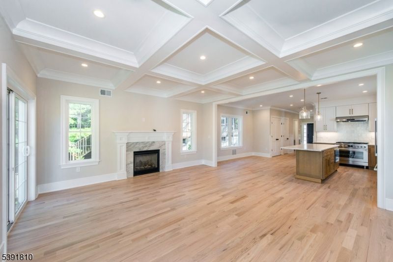 Empty room, Fireplace, Interior, Kitchen, Pendant Lights, Recessed Lighting, Stainless Steel Appliances, Wood Texture Flooring