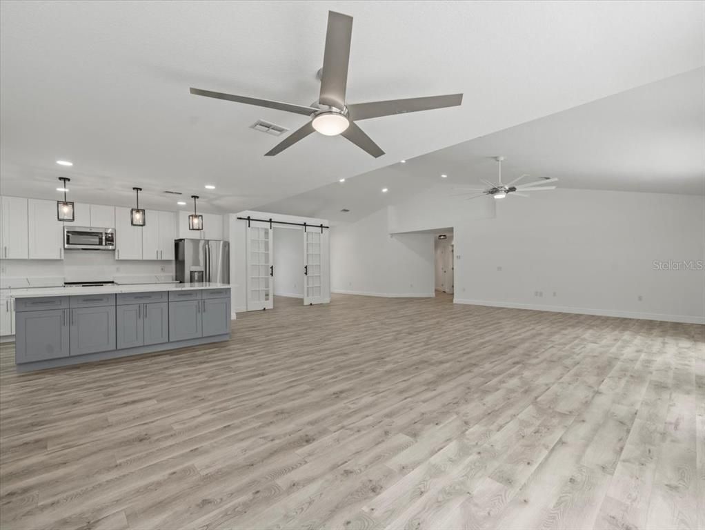 Empty room, Interior, Kitchen, Pendant Lights, Recessed Lighting, Stainless Steel Appliances, Wood Texture Flooring