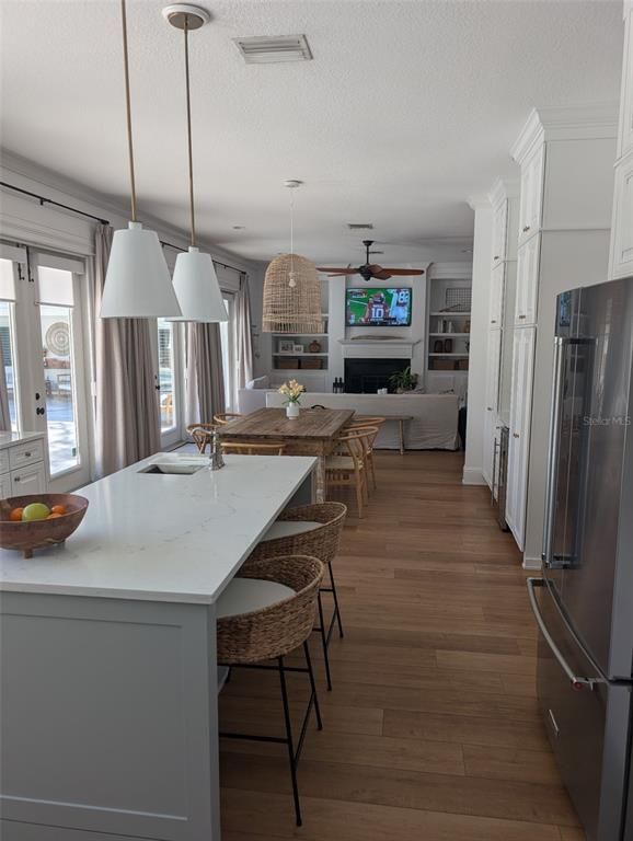Dining room, Fireplace, Interior, Kitchen, Living room, Pendant Lights, Stainless Steel Appliances, Wood Texture Flooring