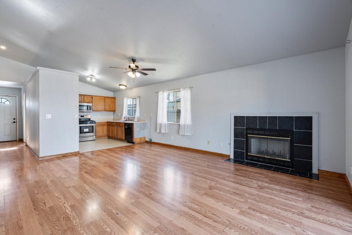 Empty room, Fireplace, Interior, Kitchen, Recessed Lighting, Stainless Steel Appliances, Wood Texture Flooring