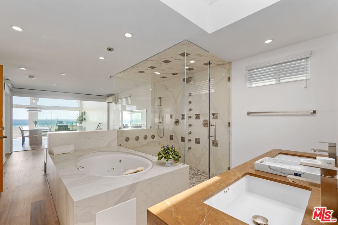 Bathroom, Dual Sink Vanities, Glass Shower, Interior, Marble Walls, Recessed Lighting, Water, Wood Texture Flooring