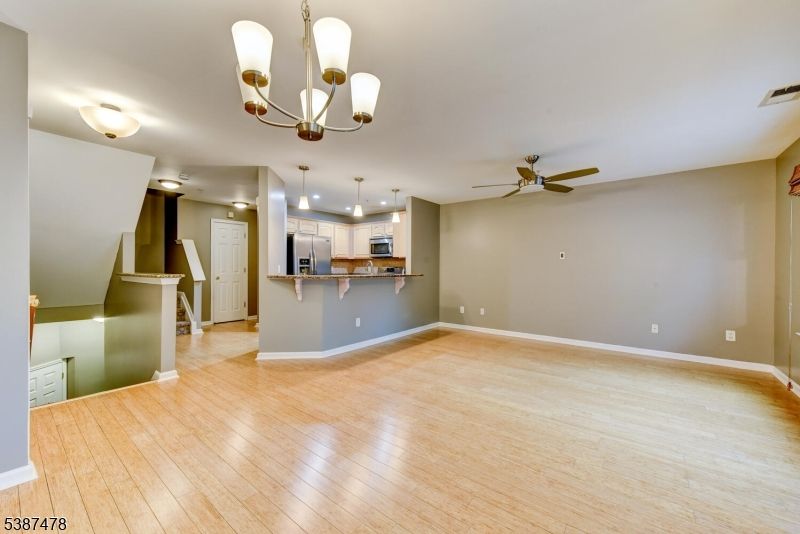 Chandelier, Empty room, Interior, Kitchen, Pendant Lights, Recessed Lighting, Stainless Steel Appliances, Wood Texture Flooring