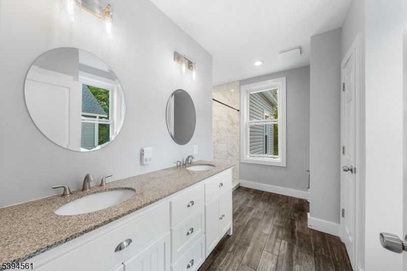 Bathroom, Dual Sink Vanities, Interior, Marble Walls, Recessed Lighting, Wood Texture Flooring
