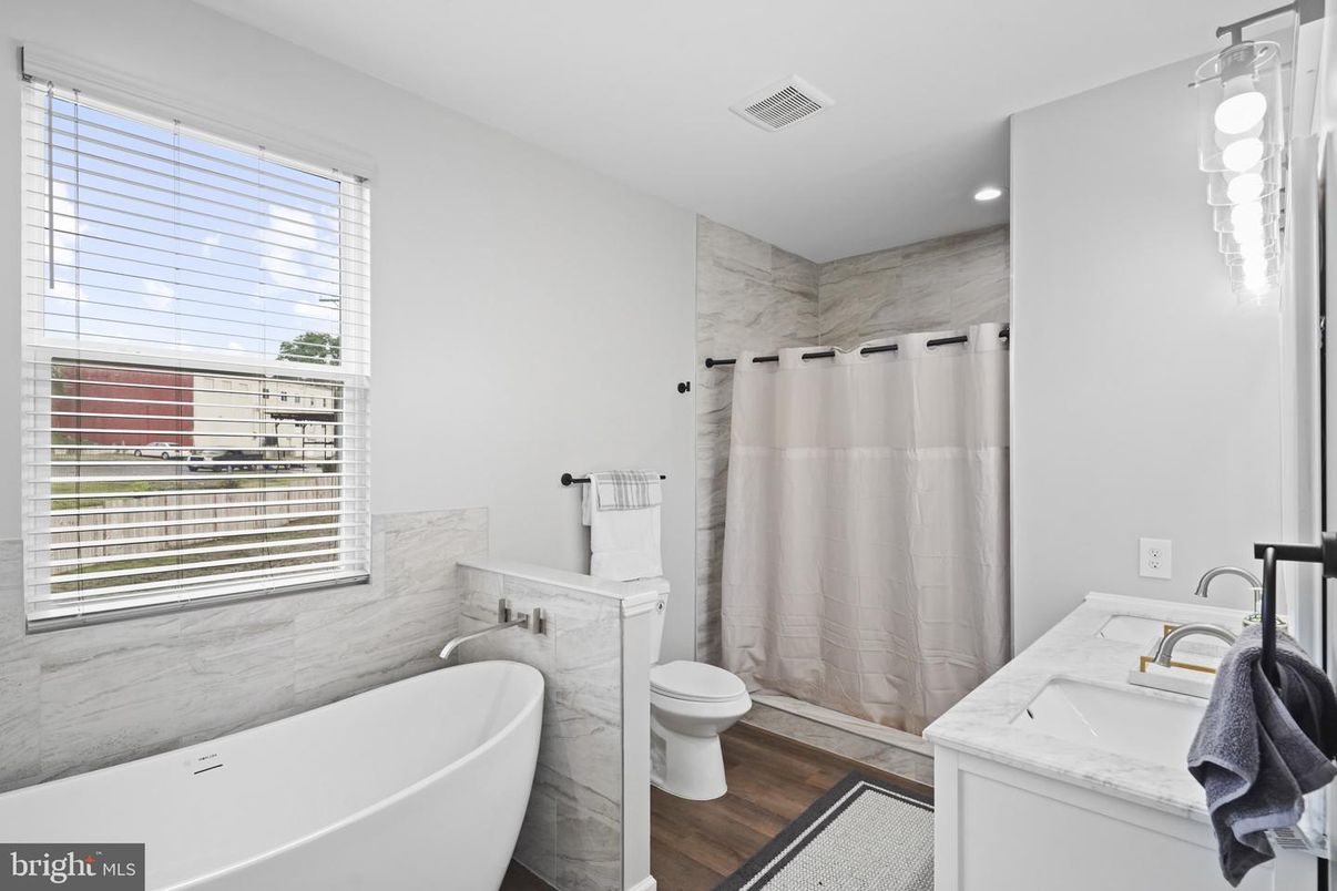 Bathroom, Dual Sink Vanities, Free Standing Baths, Interior, Marble Walls, Recessed Lighting, Wood Texture Flooring