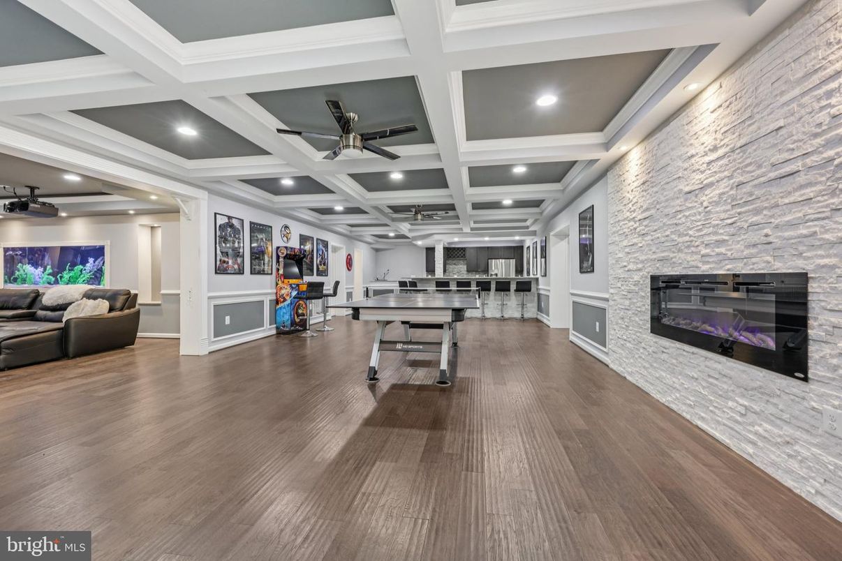 Fireplace, Game Room, Interior, Living room, Recessed Lighting, Stone Walls, Wood Texture Flooring