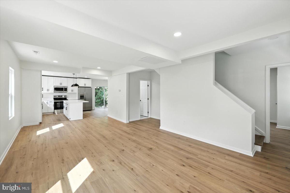 Empty room, Interior, Kitchen, Recessed Lighting, Stainless Steel Appliances, Wood Texture Flooring