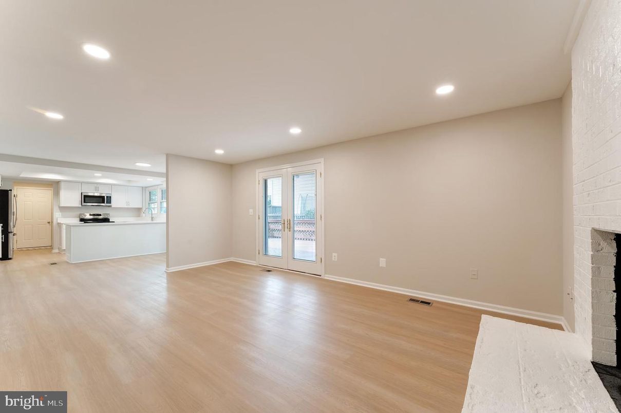Empty room, Fireplace, Interior, Kitchen, Recessed Lighting, Stainless Steel Appliances, Wood Texture Flooring