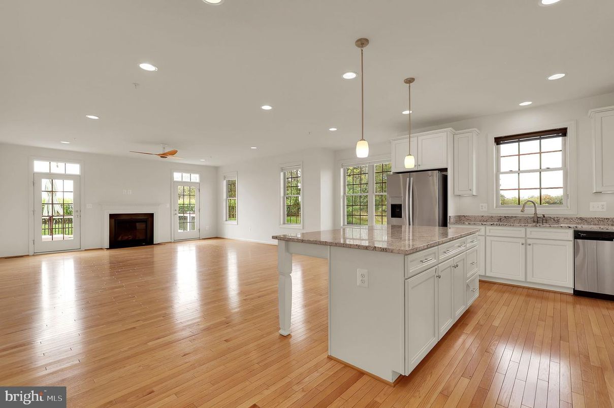 Empty room, Fireplace, Interior, Kitchen, Pendant Lights, Recessed Lighting, Stainless Steel Appliances, Wood Texture Flooring