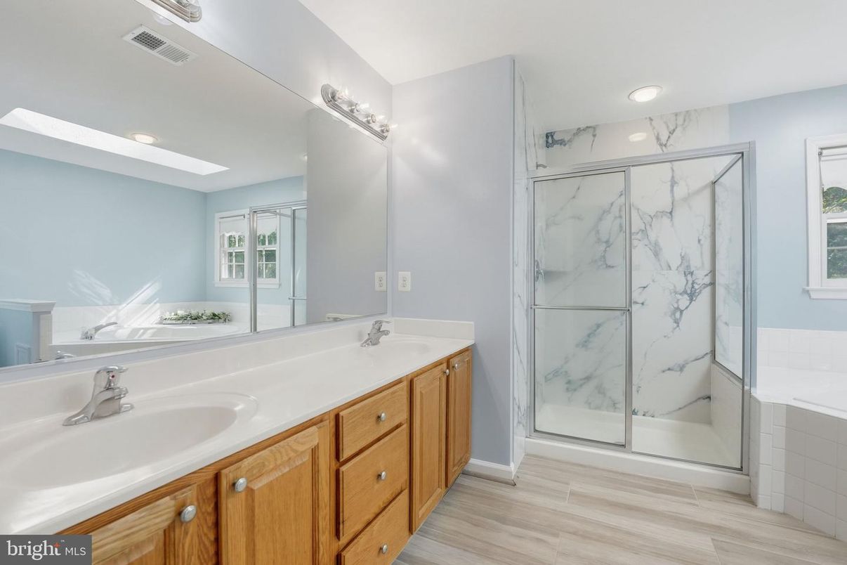 Bathroom, Dual Sink Vanities, Glass Shower, Interior, Marble Walls, Recessed Lighting, Wood Texture Flooring
