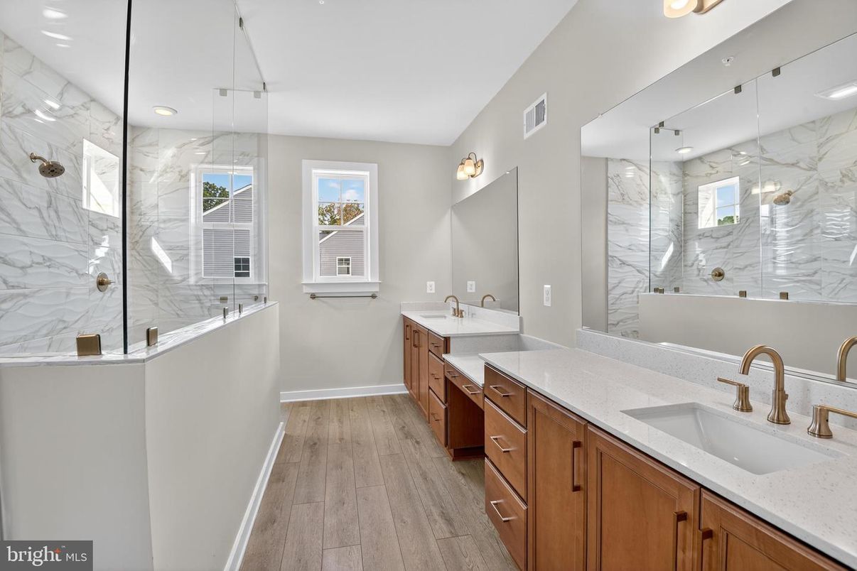 Bathroom, Dual Sink Vanities, Glass Shower, Interior, Marble Walls, Recessed Lighting, Wood Texture Flooring