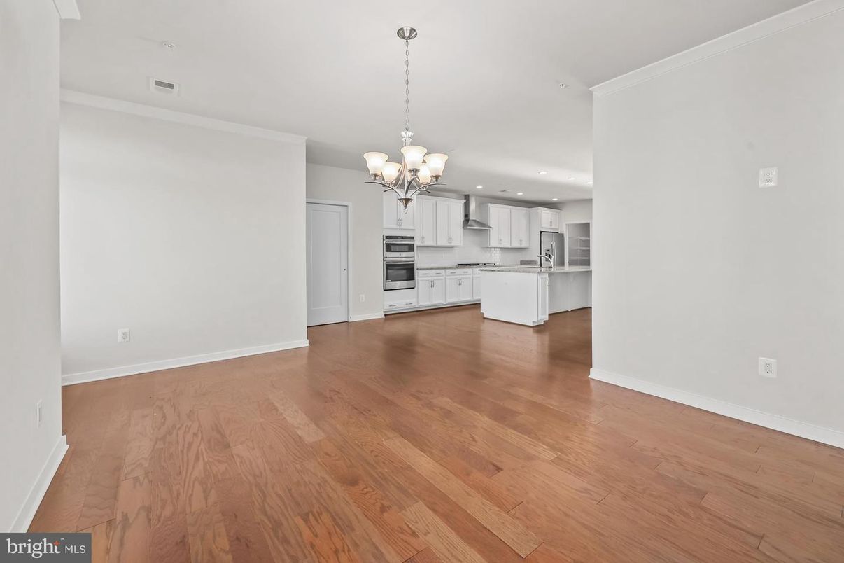 Chandelier, Empty room, Interior, Kitchen, Pendant Lights, Recessed Lighting, Stainless Steel Appliances, Wood Texture Flooring