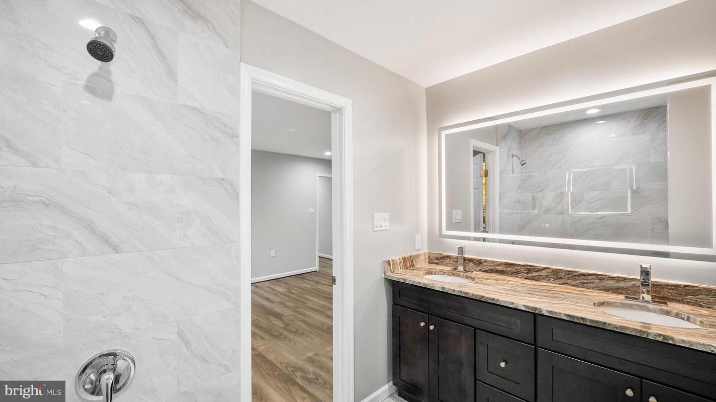 Bathroom, Dual Sink Vanities, Interior, Marble Walls, Recessed Lighting, Wood Texture Flooring