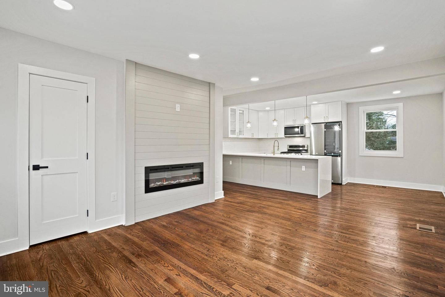 Empty room, Fireplace, Interior, Kitchen, Recessed Lighting, Stainless Steel Appliances, Wood Texture Flooring