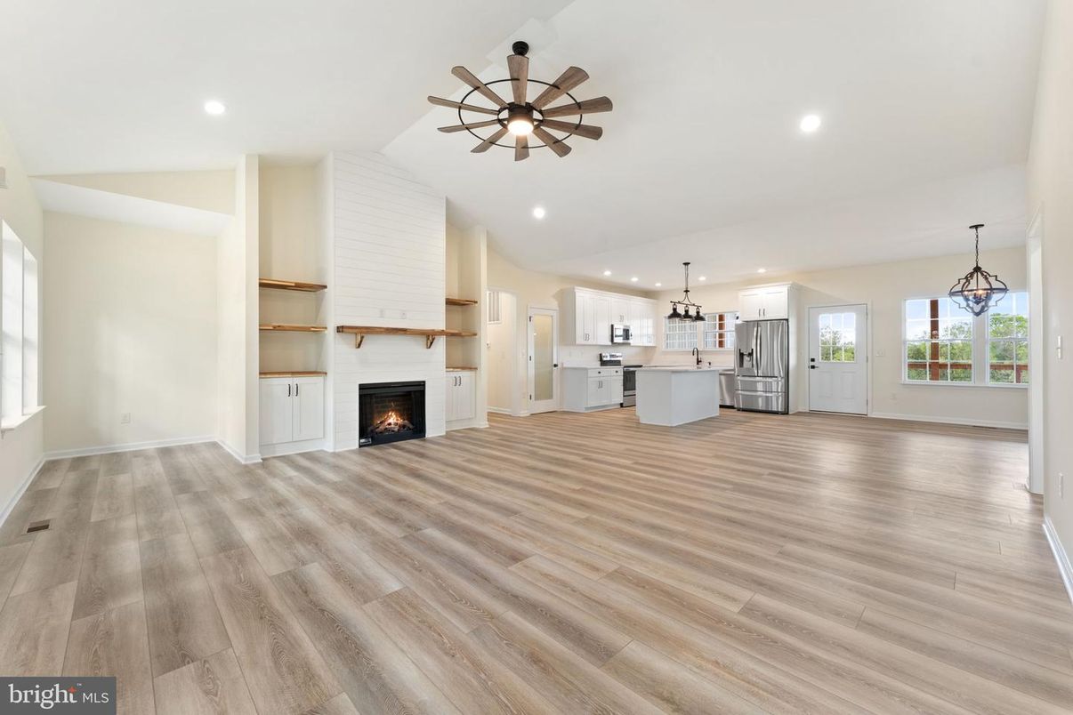 Empty room, Fireplace, Interior, Kitchen, Pendant Lights, Recessed Lighting, Stainless Steel Appliances, Wood Texture Flooring