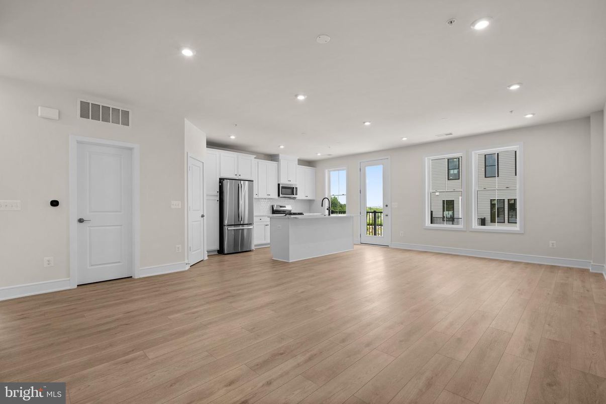 Empty room, Interior, Kitchen, Recessed Lighting, Stainless Steel Appliances, Wood Texture Flooring