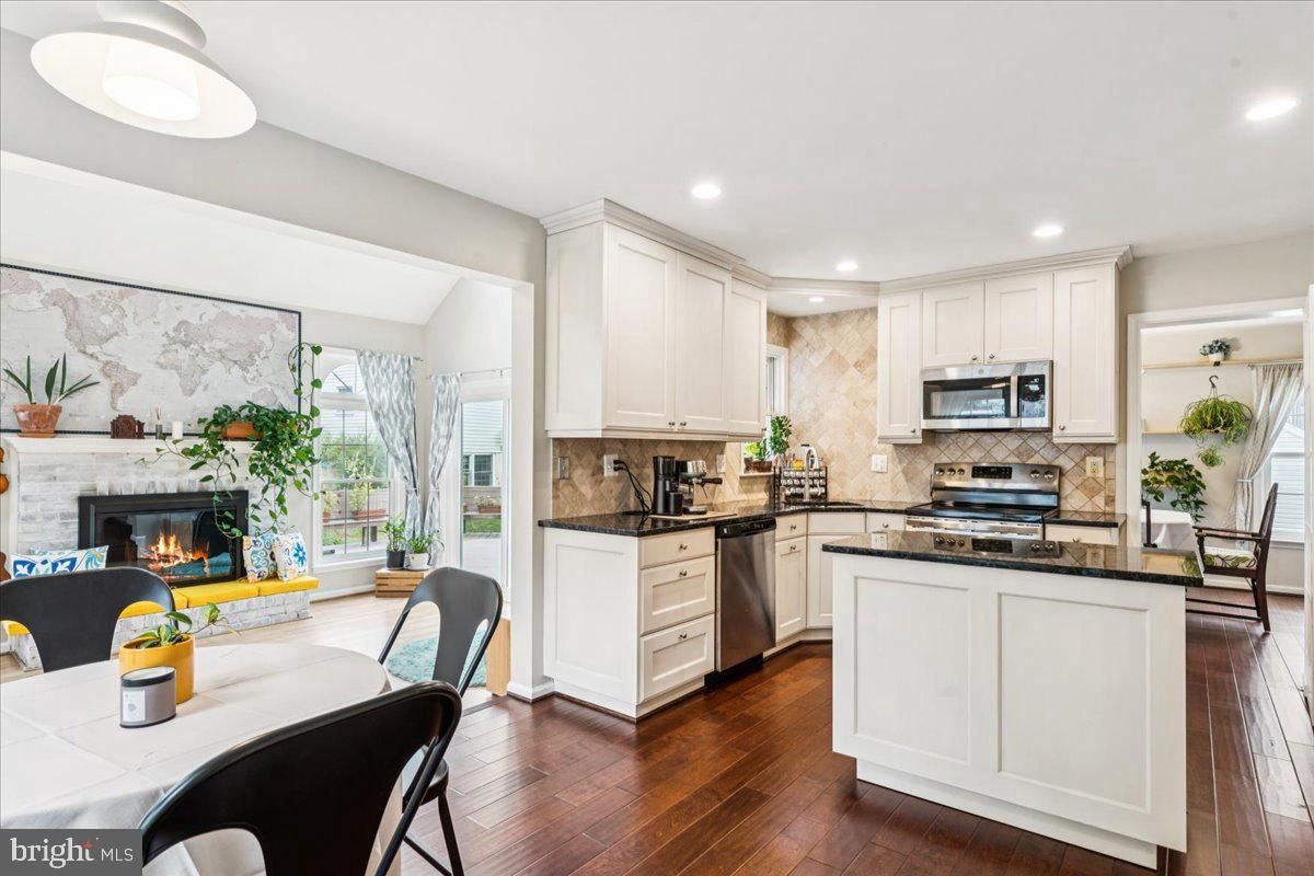 Dining room, Fireplace, Interior, Kitchen, Recessed Lighting, Stainless Steel Appliances, Wood Texture Flooring