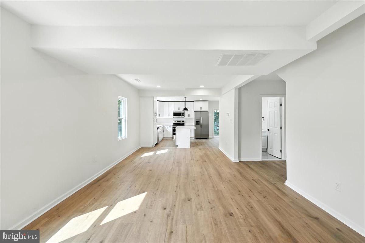 Empty room, Interior, Kitchen, Recessed Lighting, Stainless Steel Appliances, Wood Texture Flooring