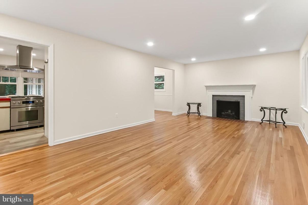 Empty room, Fireplace, Interior, Kitchen, Recessed Lighting, Stainless Steel Appliances, Wood Texture Flooring