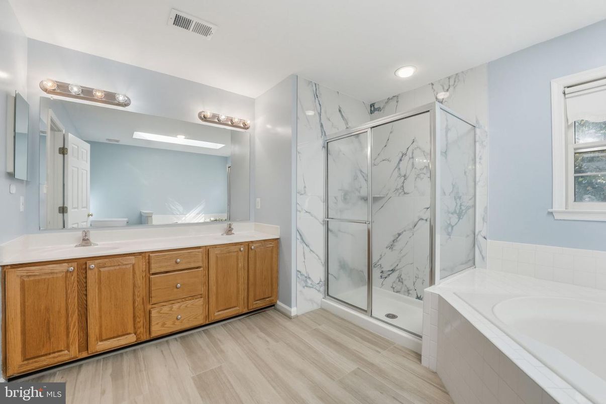 Bathroom, Dual Sink Vanities, Glass Shower, Interior, Marble Walls, Recessed Lighting, Wood Texture Flooring