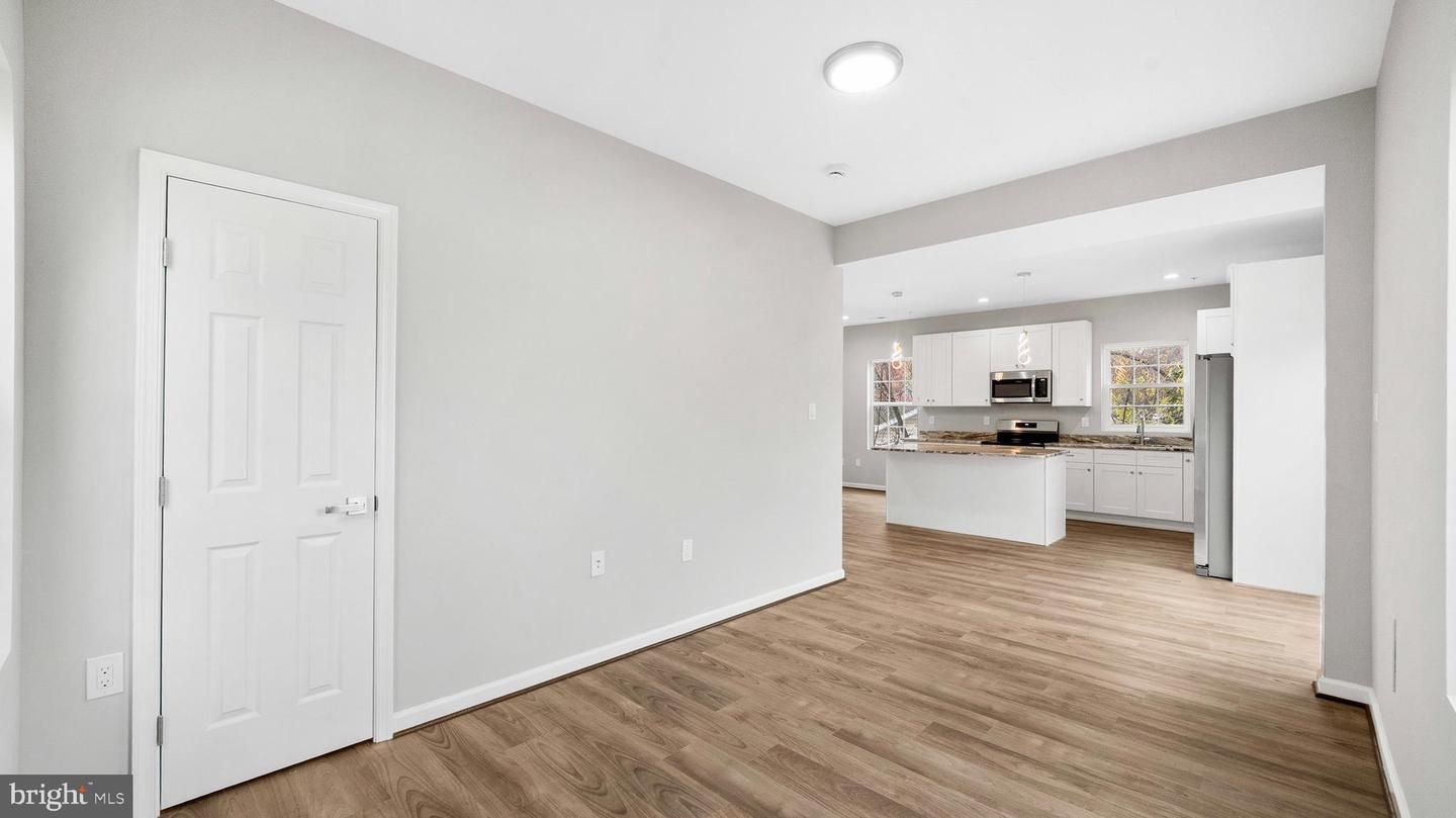 Empty room, Interior, Kitchen, Recessed Lighting, Stainless Steel Appliances, Wood Texture Flooring