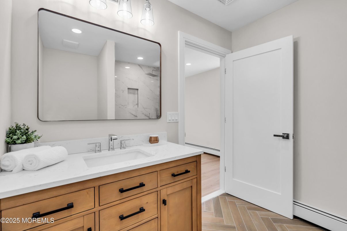 Bathroom, Dual Sink Vanities, Interior, Marble Walls, Recessed Lighting, Wood Texture Flooring