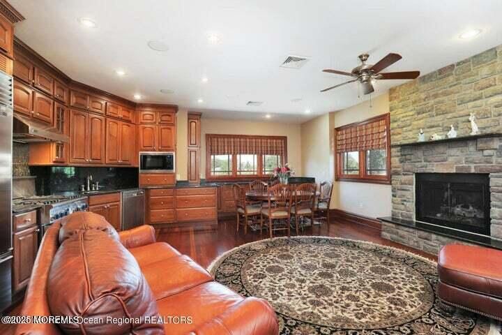 Dining room, Fireplace, Interior, Kitchen, Living room, Recessed Lighting, Stainless Steel Appliances, Stone Walls, Wood Texture Flooring
