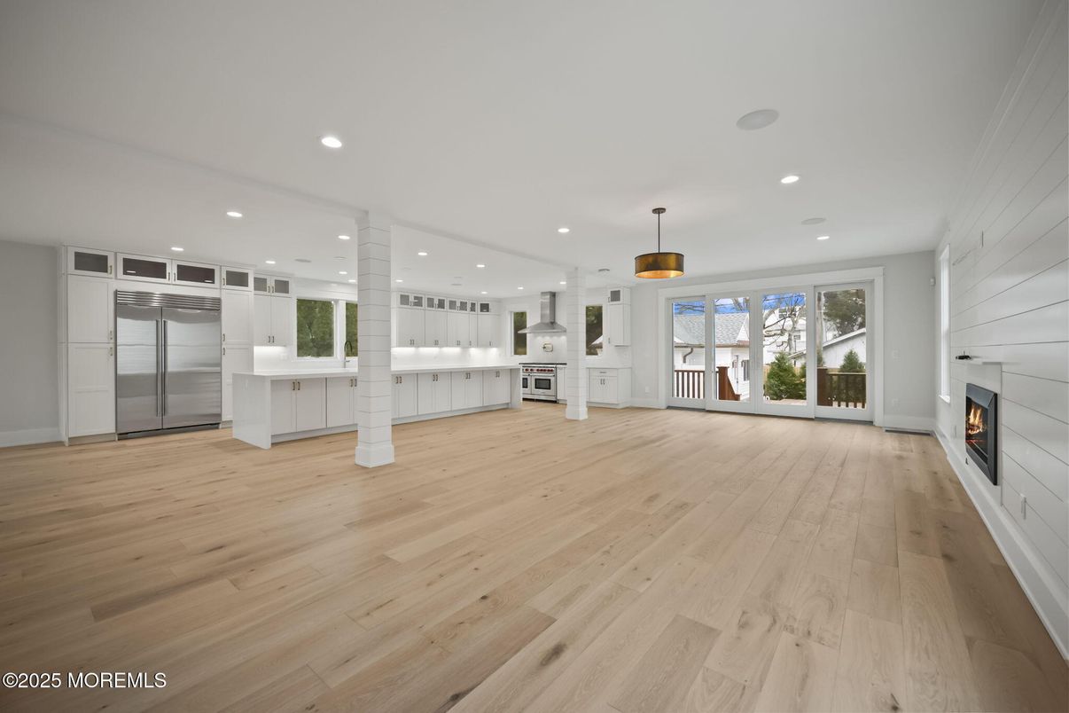 Empty room, Fireplace, Interior, Kitchen, Pendant Lights, Recessed Lighting, Stainless Steel Appliances, Wood Texture Flooring