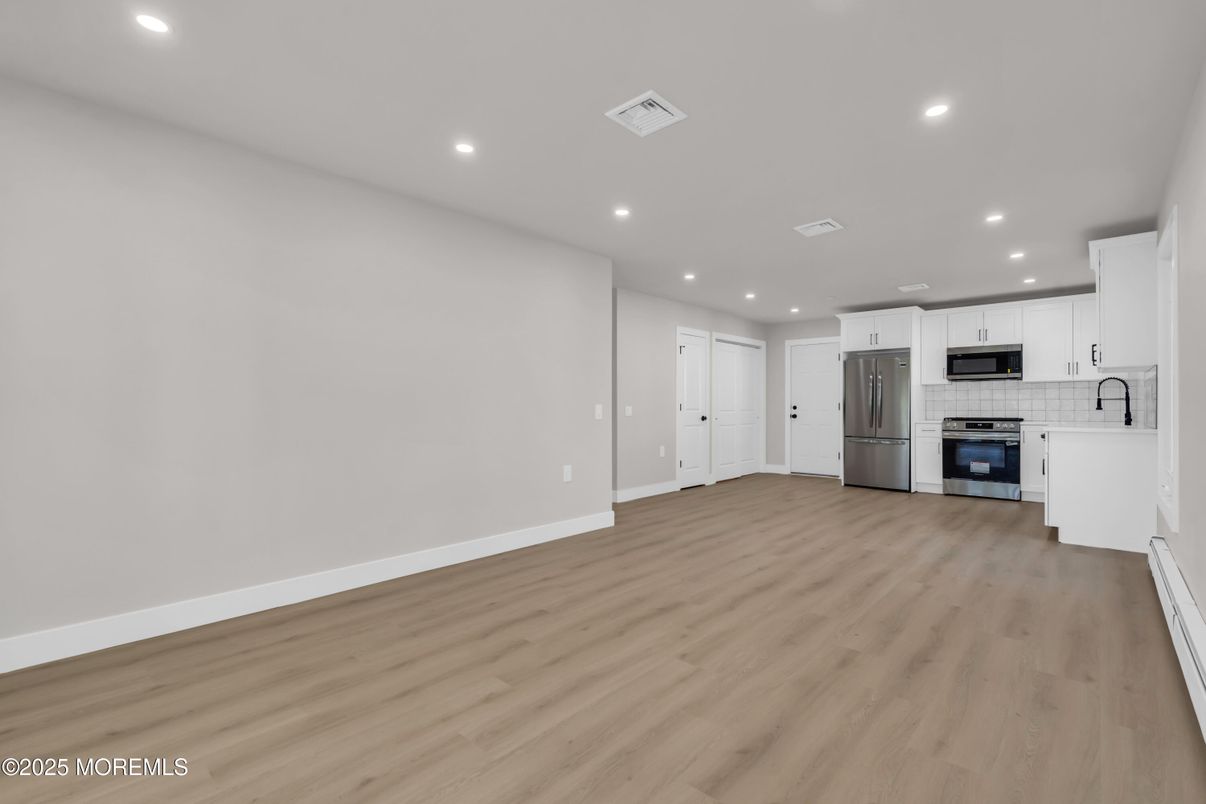 Empty room, Interior, Kitchen, Recessed Lighting, Stainless Steel Appliances, Wood Texture Flooring